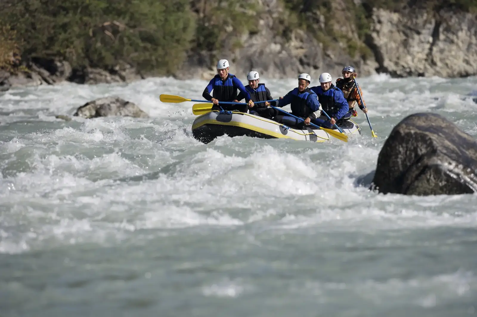 Team beim Wildwasser-Rafting als Sinnbild für Zusammenarbeit unter Druck