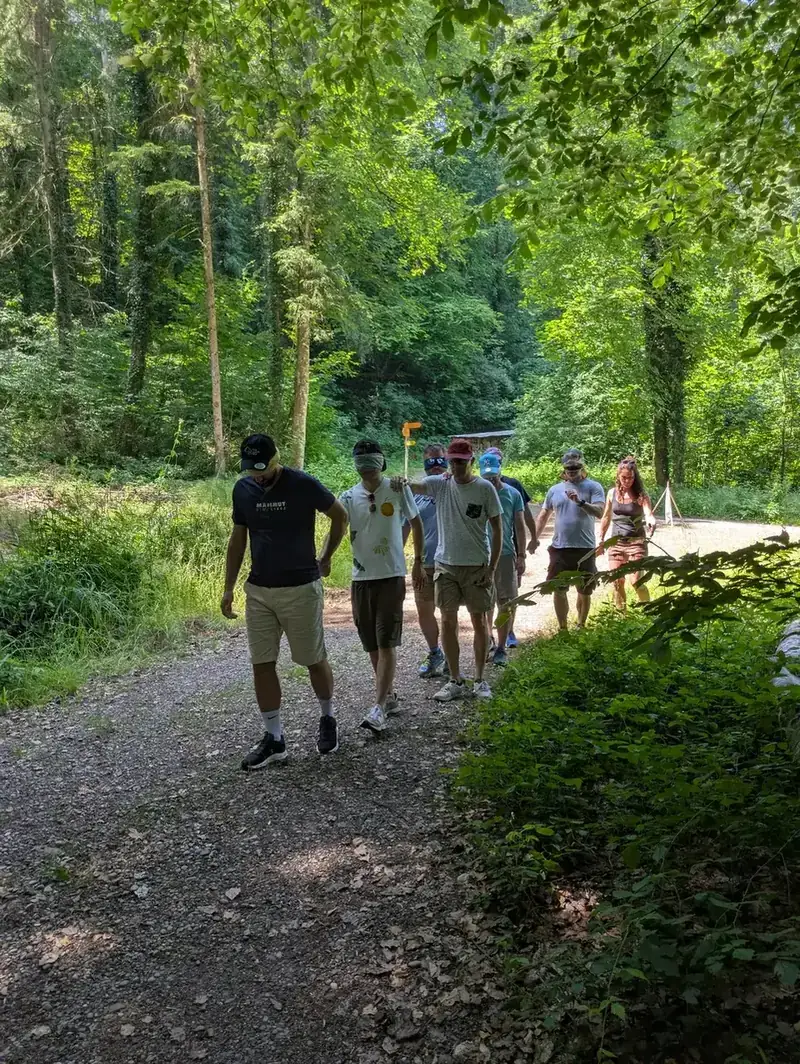 Teilnehmende bei einer gemeinsamen Outdoor-Übung im Wald